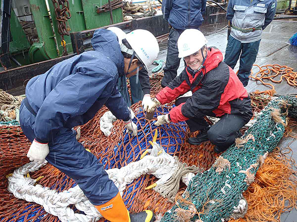 Government Officer inspects a fishing net prior to licensing a trawler.